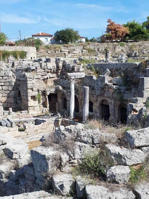 미케네 유적지에 남아 있는 고대 석조 건축물과 두 개의 돌기둥, 작은 방의 입구가 보인다.