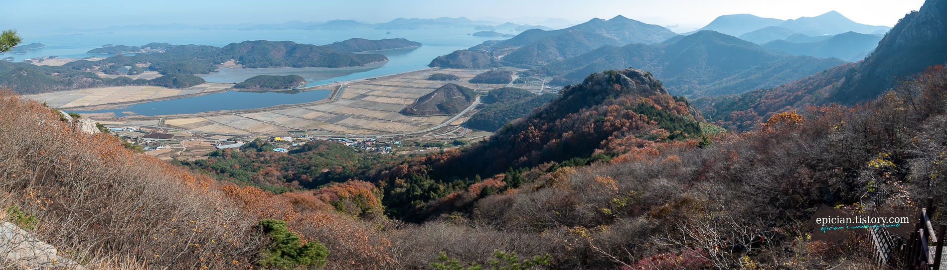바다를 배경으로 울긋불긋 단풍이 내려앉은 산야