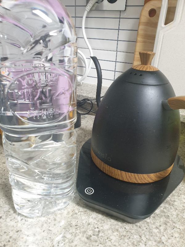 테이블 위에 2L 생수와 드립포트가 놓여 있다.