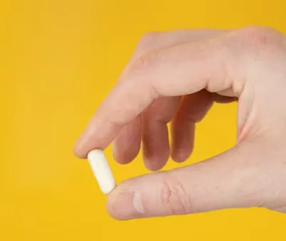 비타민 한 개를 들고 있는 모습