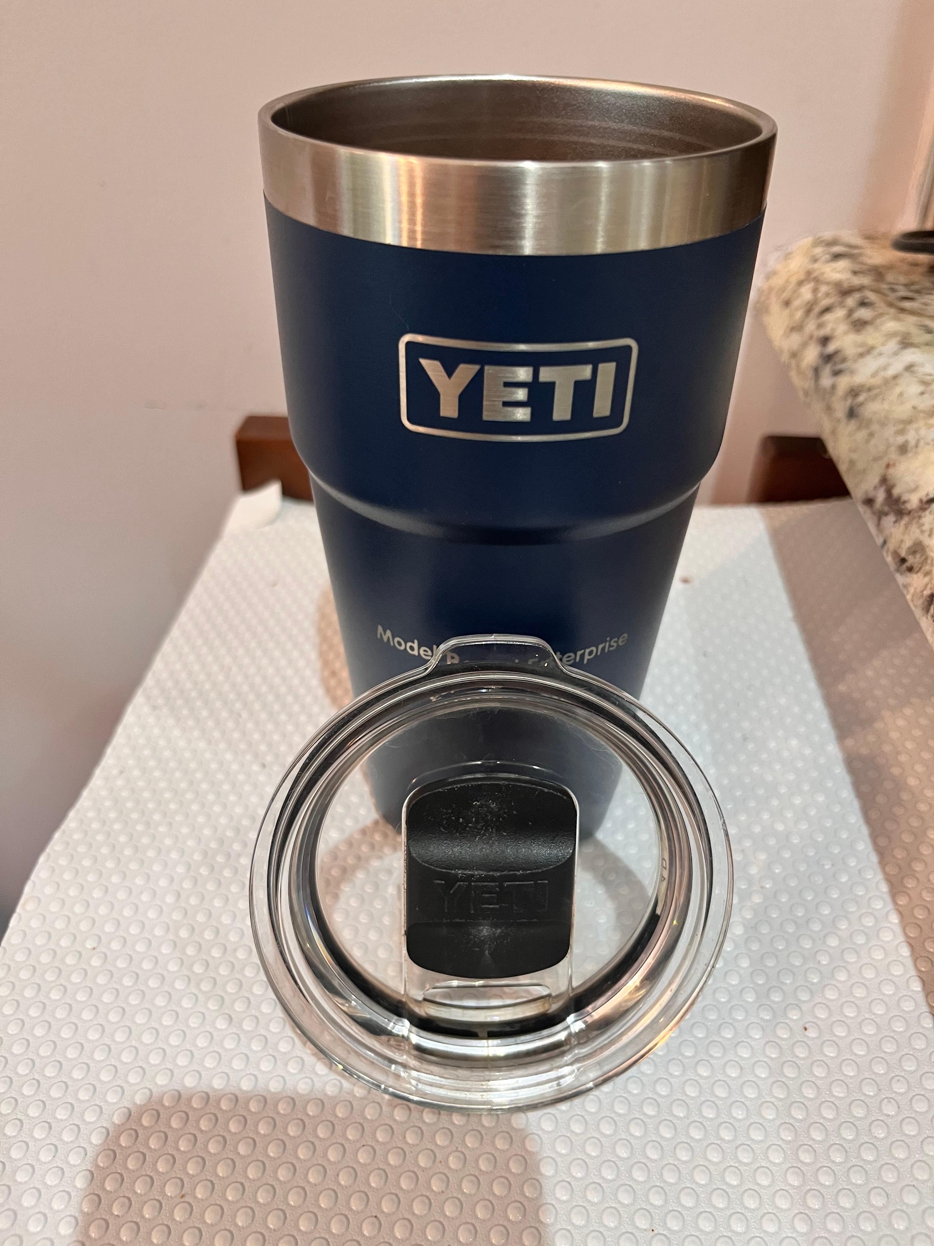 yeti 새겨진 텀블러와 뚜껑이 열려 있는 모습