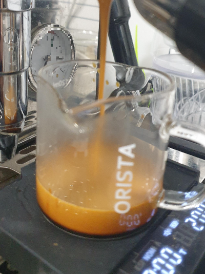 투명한 에스프레소 잔에 에스프레소를 추출하는 중