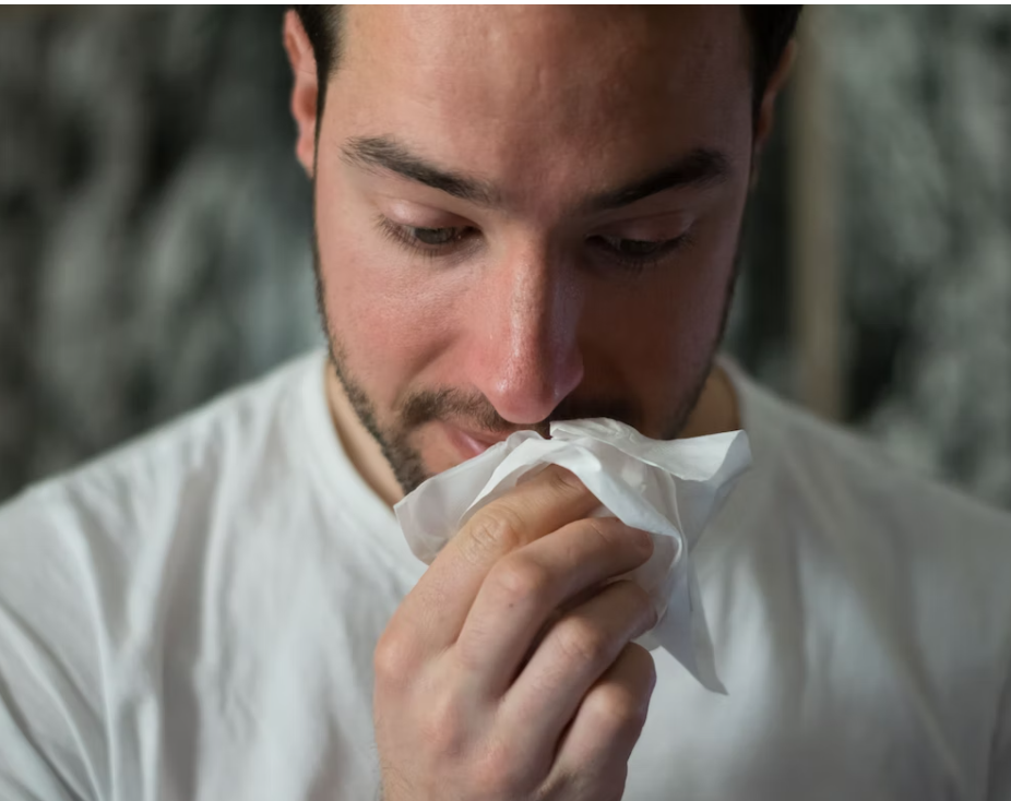 콧물을 닦고 있는 남자의 사진