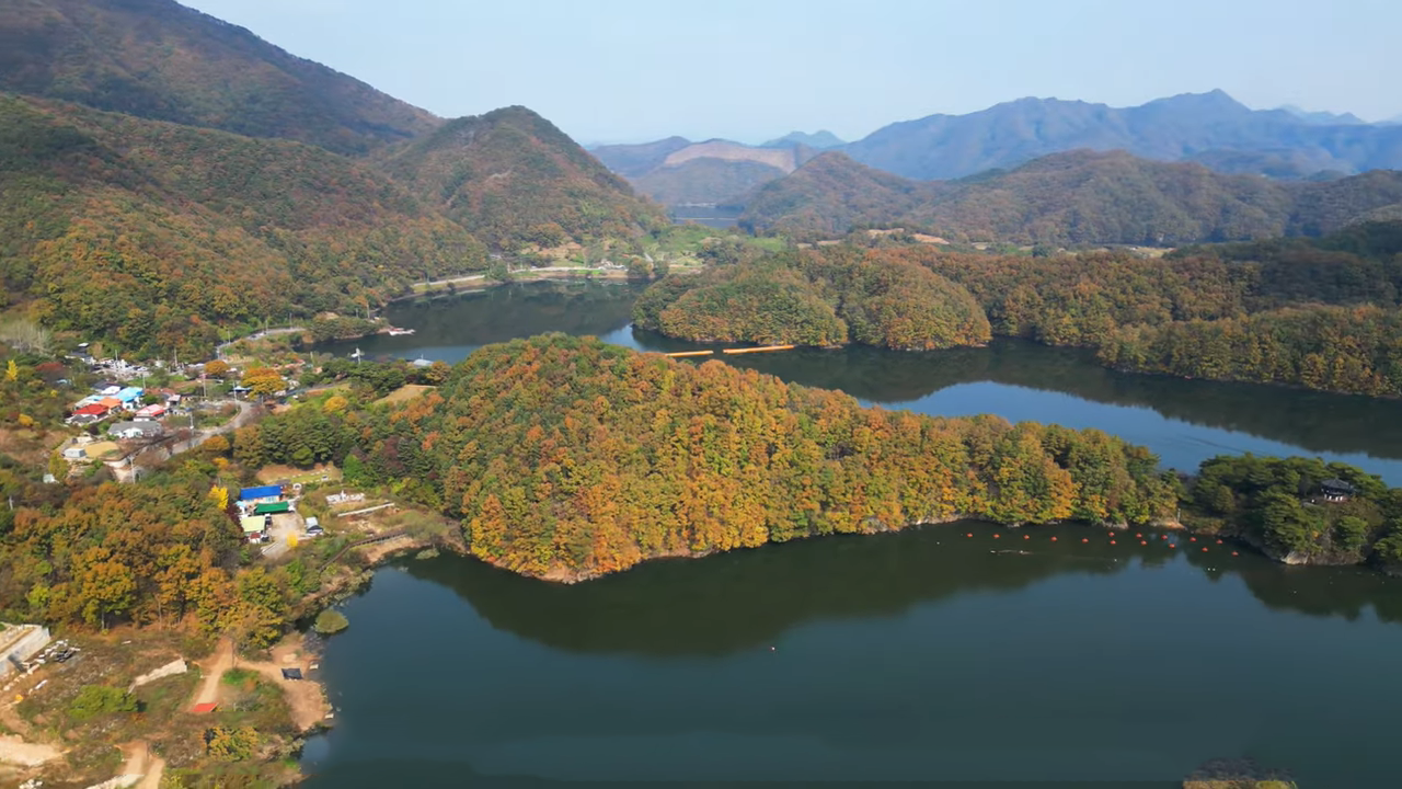 가을에 물든 섬 능선과 마을 전경을 담은 상공 파노라마.