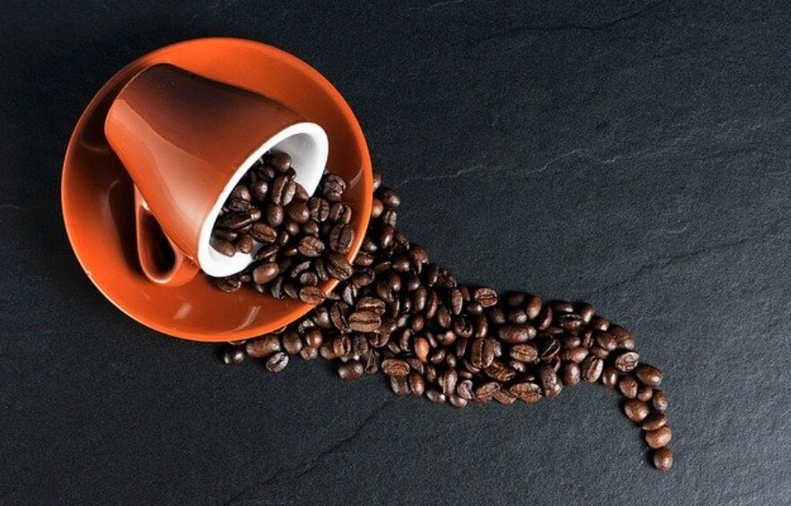 커피잔에-가득있는-커피-원두-흘러-나와있는-사진