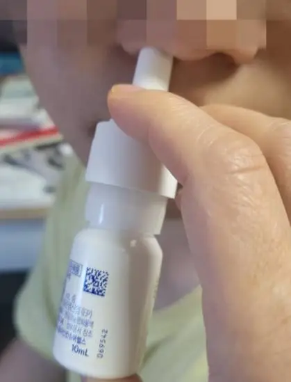 오트리빈을 왼쪽 콧구멍에 넣고 두번째 손가락과 세번째 손가락으로 펌프를 누르고 있는 모습