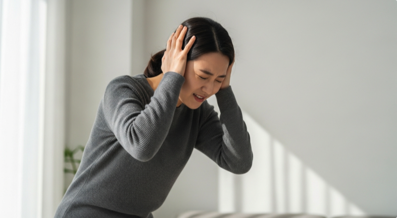머리 통증과 함께 어지러움을 느끼는 모습
