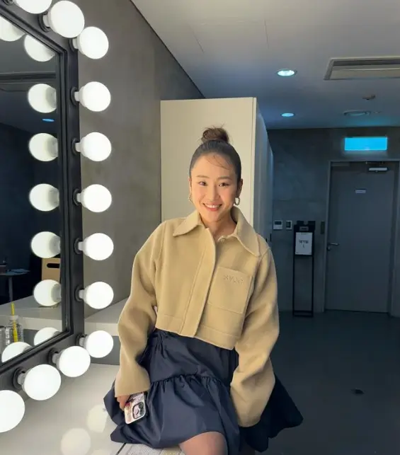 나솔사계- 머리를 하나로 위로 묶어 올린머리 베이지색 쟈켓 파란색 미니스커트를 입고 탁자에 걸터앉아 웃고있는 조현아