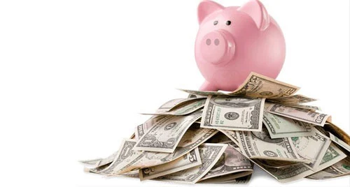 쌓인-지폐-위에-놓인-돼지저금통