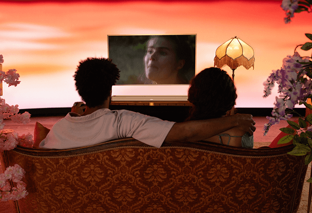 사운드바 설치 후 쇼파에서 두명이 티비 시청하는 모습