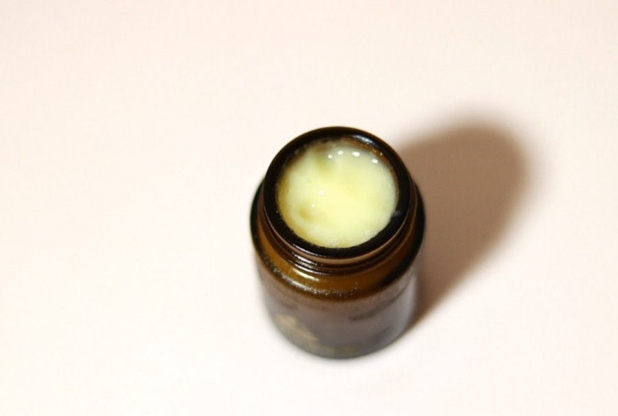 야생에서 채취를 한 여왕벌의 먹이인 로열젤리를 갈색의 유리병에 가득 채워 놓은 것을 하얀 바닥 위에 놓아두고 찍은 사진