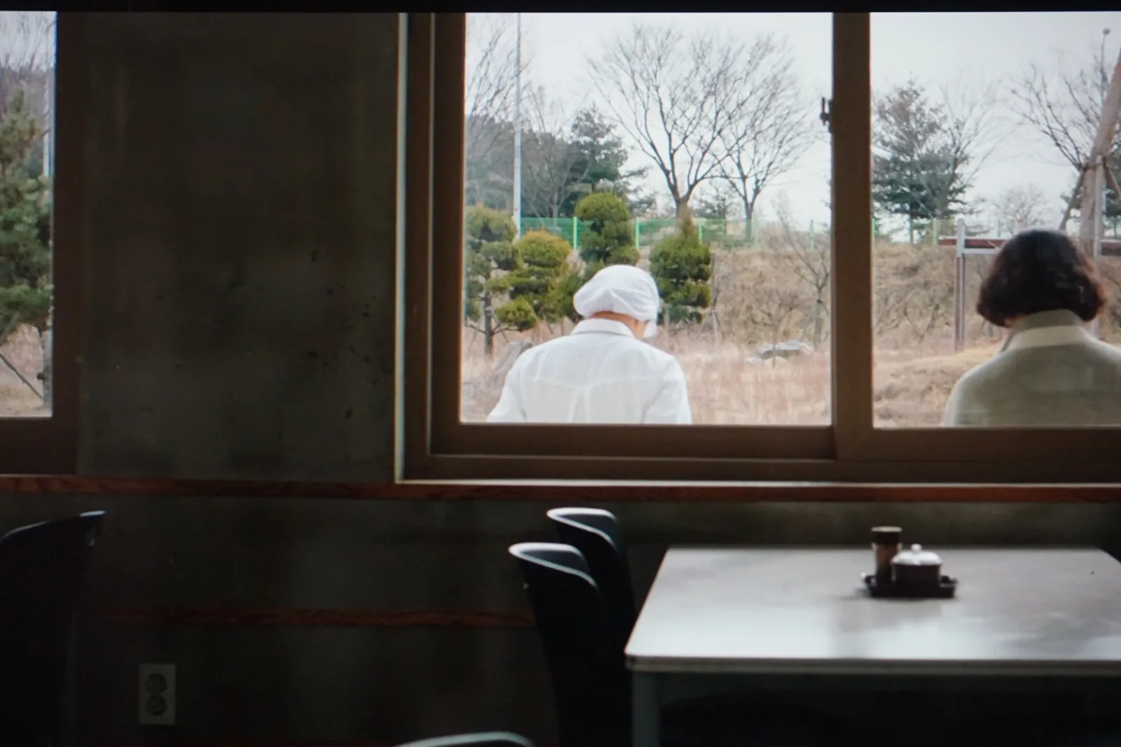 <img src="식당_창밖_겨울_풍경.webp" 
 alt="식당 안에서 바라본 창밖의 겨울 풍경과 조리원, 영양사의 뒷모습" 
 width="1600" 
 height="1065" 
 loading="lazy" 
 style="max-width:100%; height:auto;" />