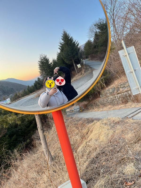 도로 반사경 앞에서 사진 찍는 모습