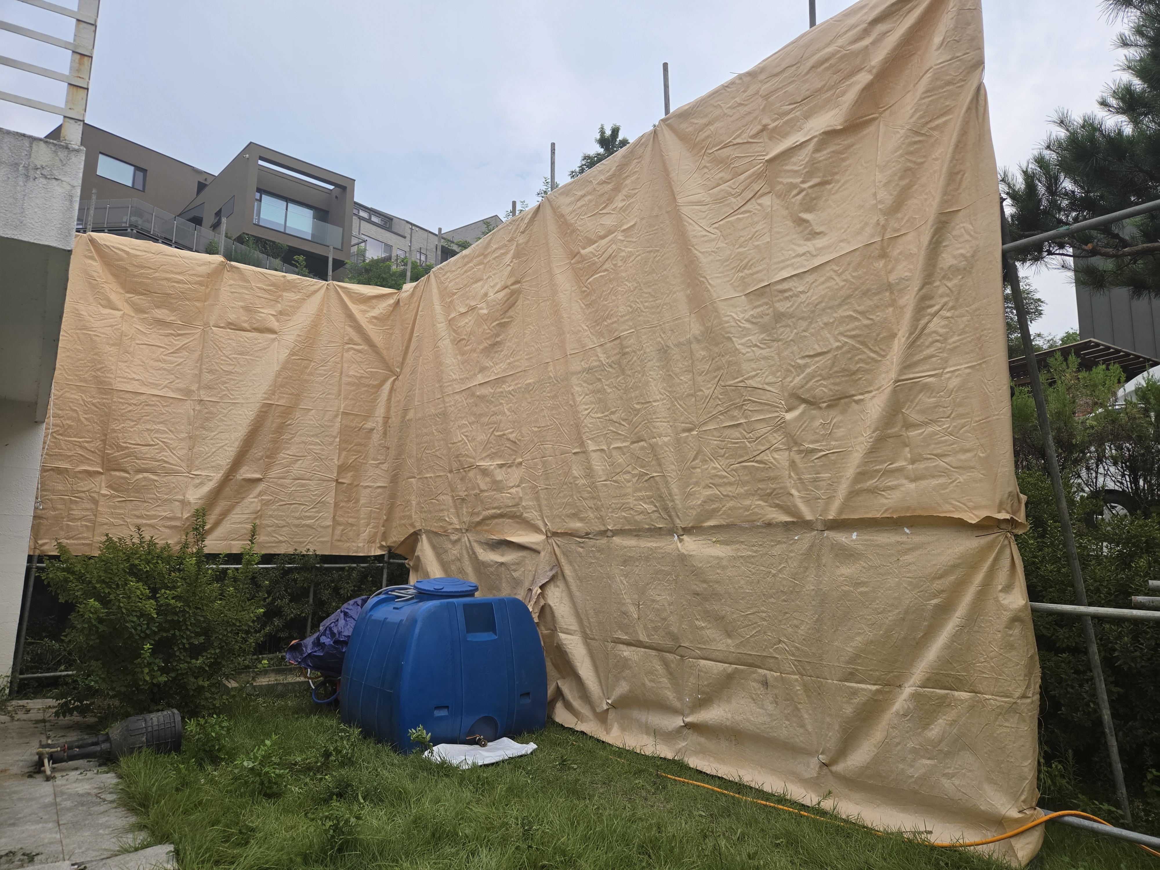 건물 주변에 설치한 가림막과 현장 안쪽 물탱크
