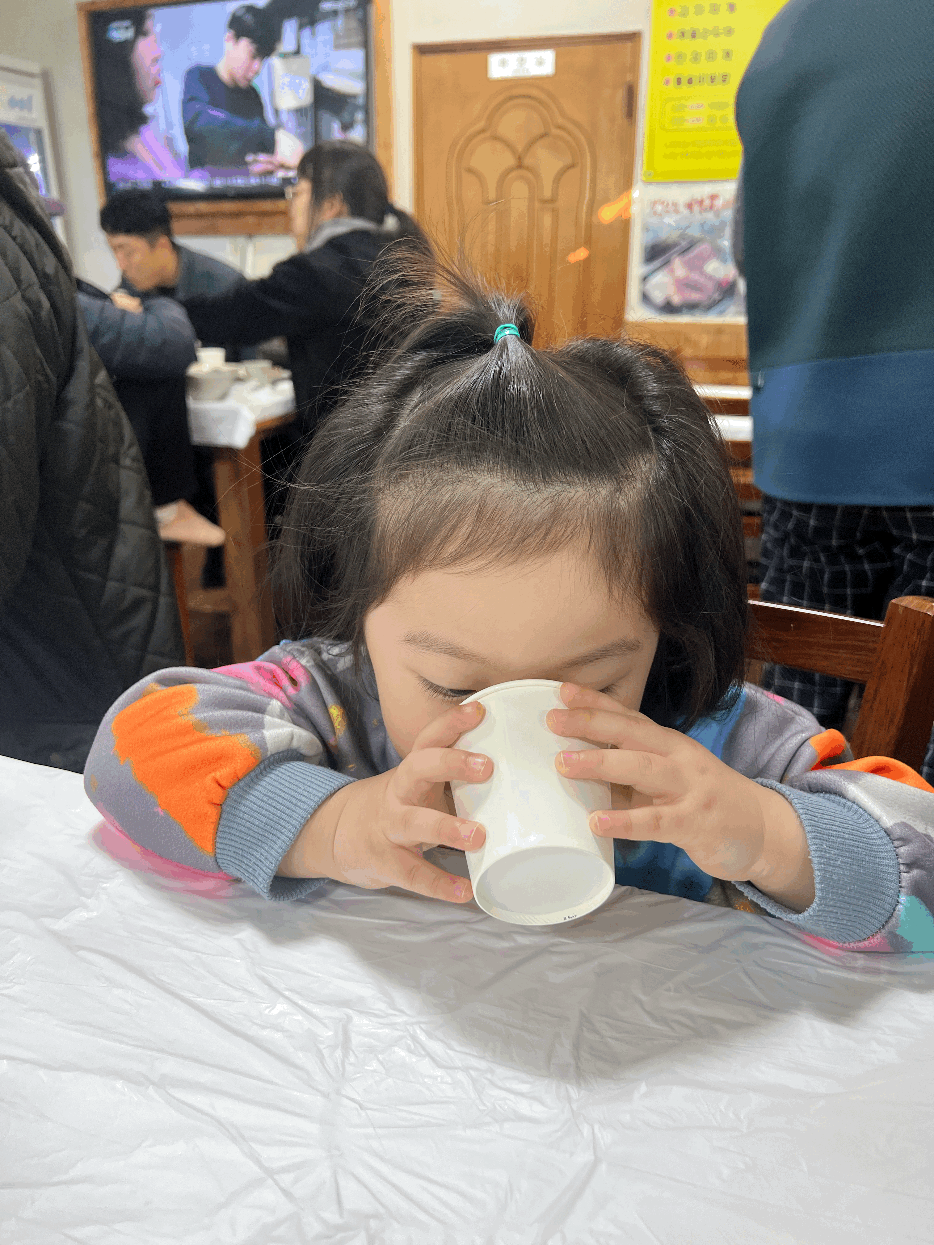 음식을 기다리며 물을 마시고 있는 아이