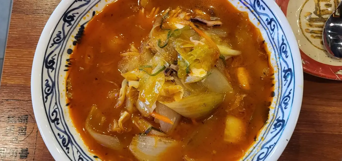 보배반점 - 흰 그릇 안쪽 파란줄무늬 그릇 안 야채와 해산물&amp;#44; 빨간 국물이 가득담긴 짬뽕