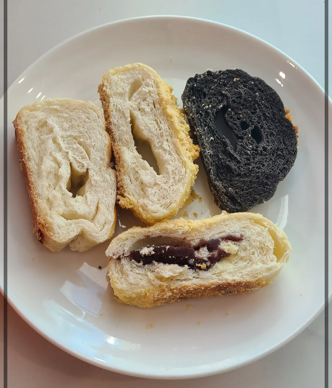 흰접시 위 함소소금빵단면 소보로함초소금빵단면 먹물함초소금빵단면 단팥소보루함초소금빵단면