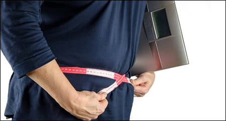 줄자로 허리둘레를 재고 있는 남성