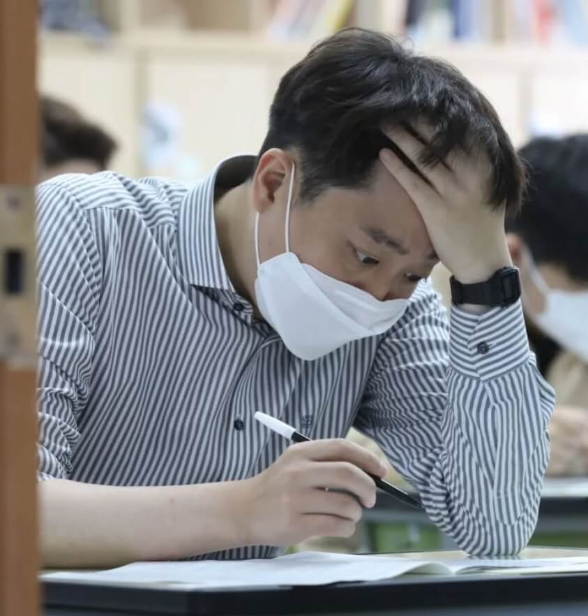 종이문서를보고있는-마스크를착용한-남성의모습