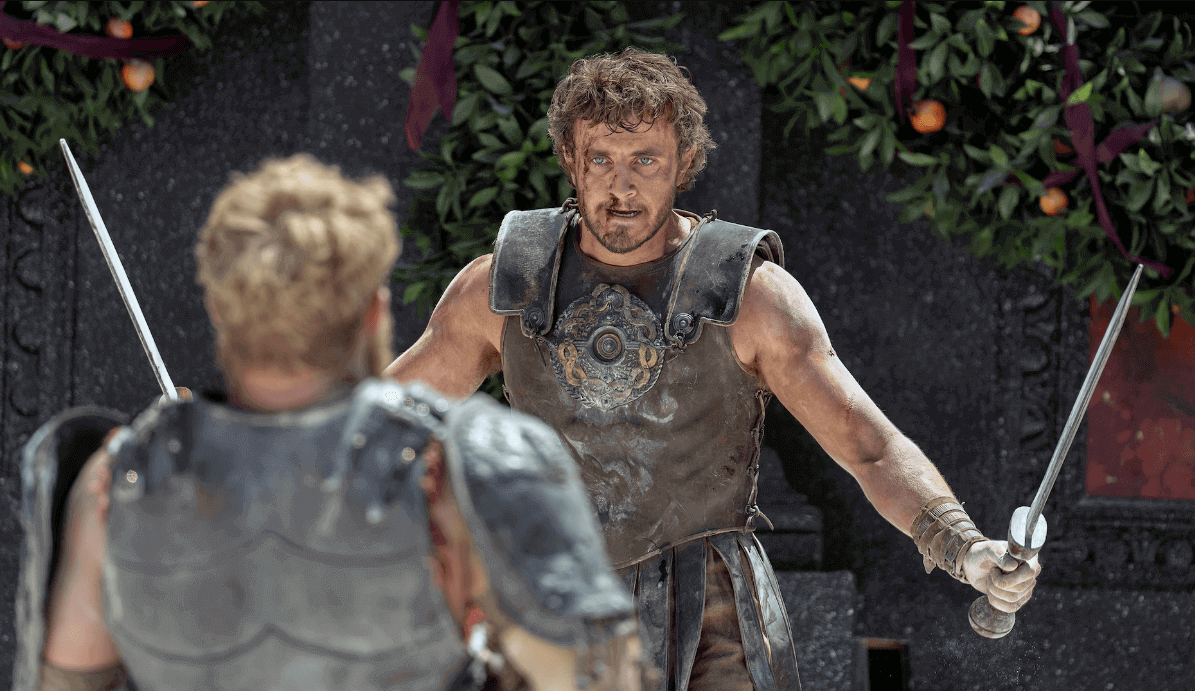 영화《Gladiator II》의 공식 이미지 : 두 남성 캐릭터가 칼을 들고 대치하고 있는 장면