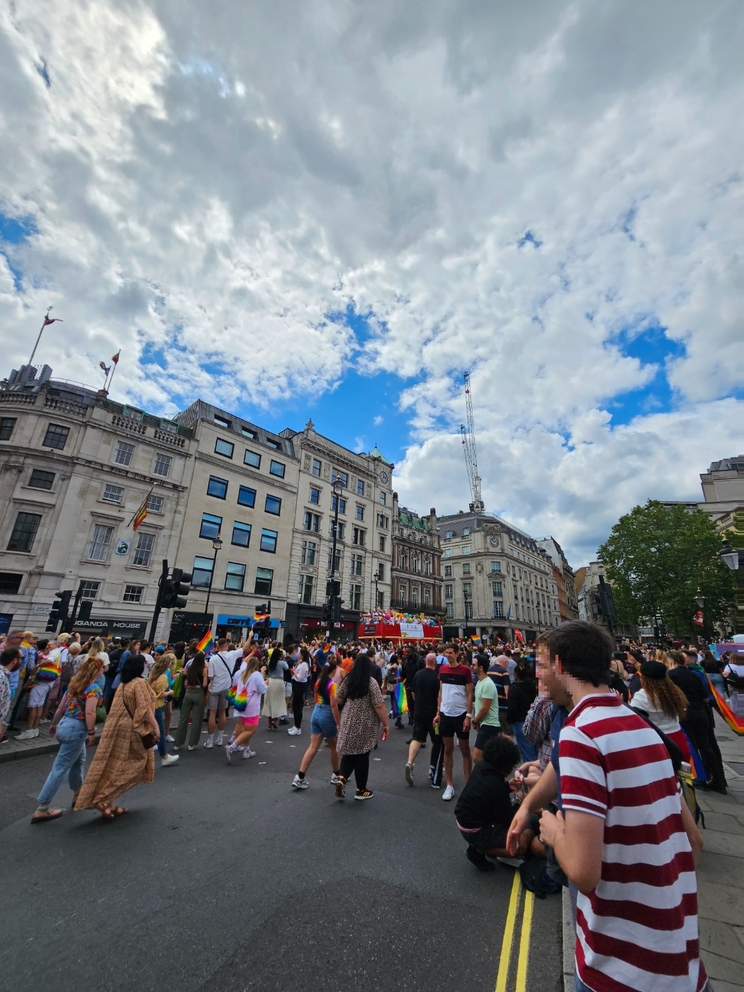 푸른 하늘 아래&amp;#44; 퀴퍼 참여 단체의 트럭이 지나간다. 많은 관중이 맞아주고 있다.