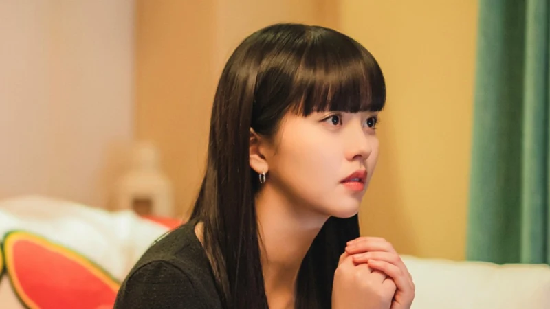 실내를 배경으로 검은티에 두손을 꼭 모으고 있는 긴머리의 목솔희