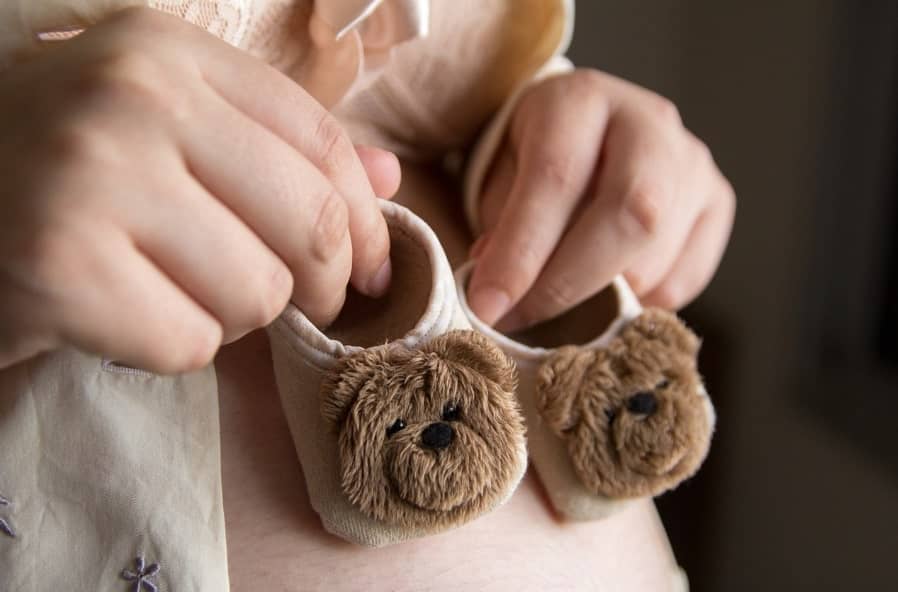 아기 신발을 들고 태어날 아기를 기다리는 임산부 사진