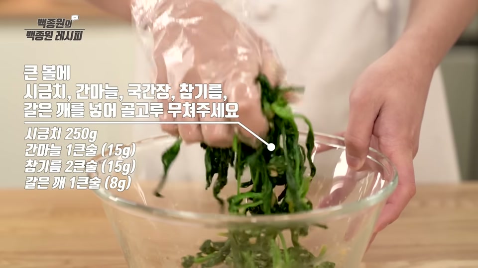 볼에서 시금치를 양념과 무치는 장면