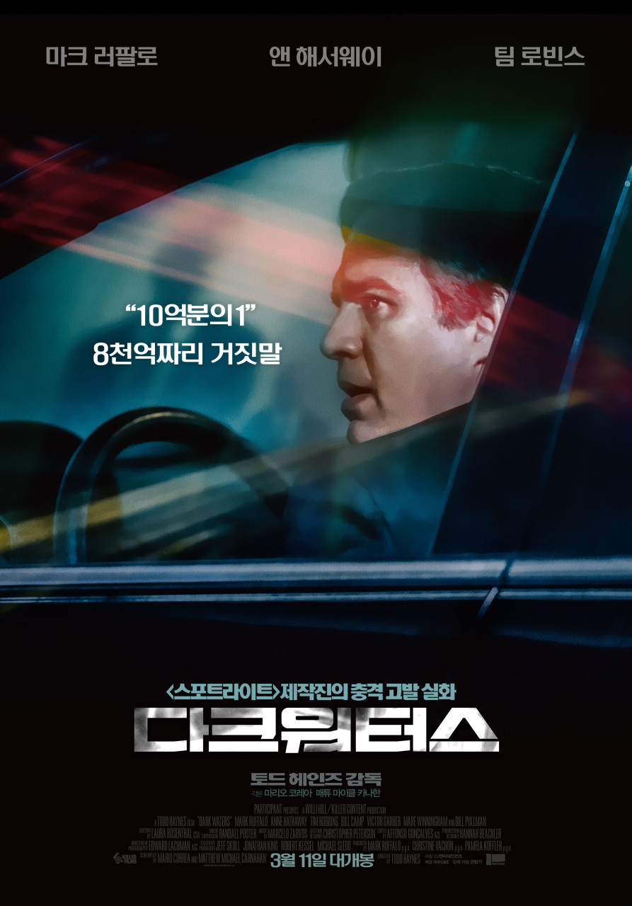 남자가 운전석에서 창 밖을 바라보고 있다.