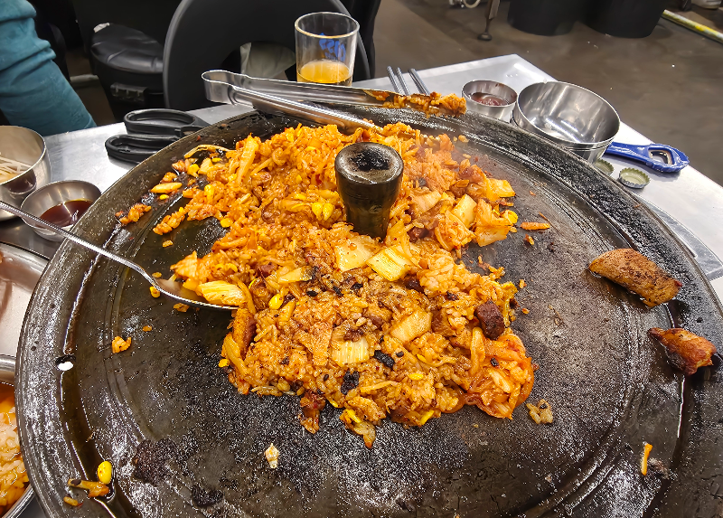 김치 볶음밥이 솥뚜껑 위에 있다