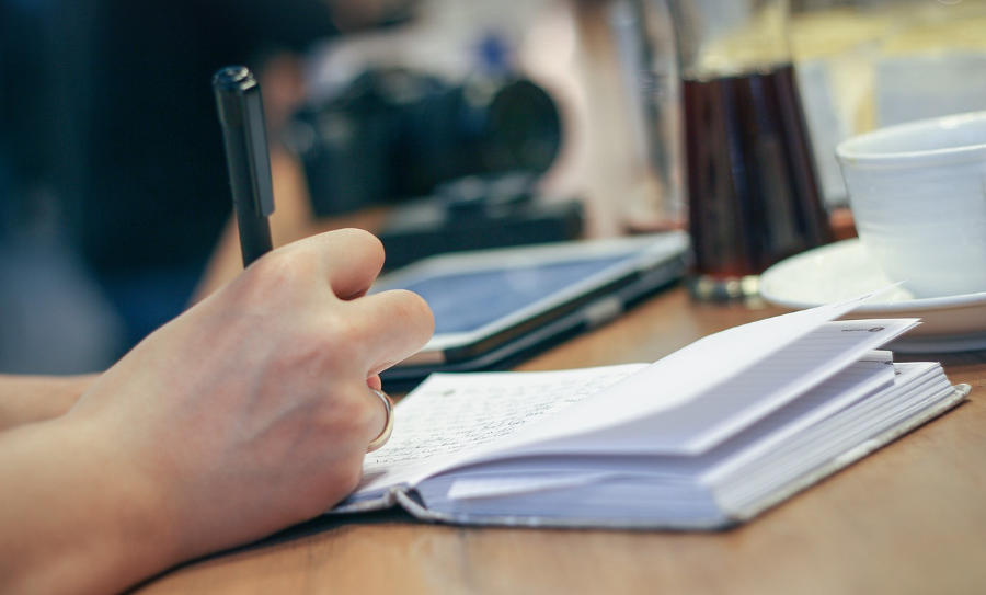 writing with a pen on a notebook