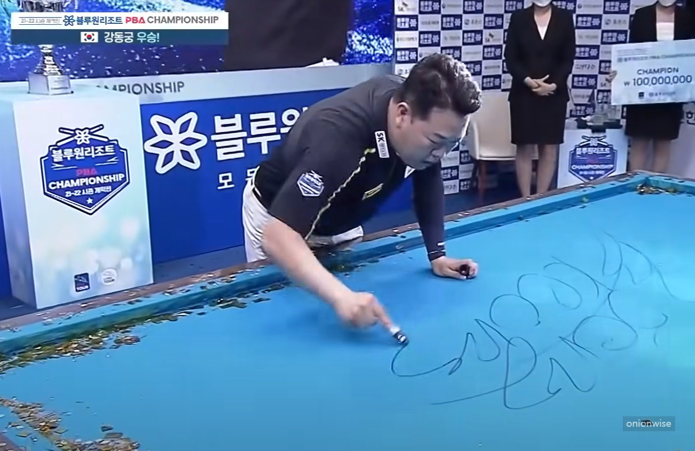 강동궁이 우승후 당구대에 사인을 하는 모습