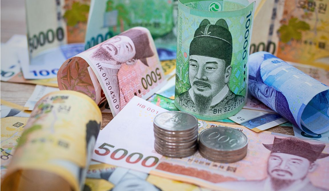 한국 지폐와 동전이 흩어져 놓인 장면, 정부와 은행이 보장하는 신뢰의 돈을 표현