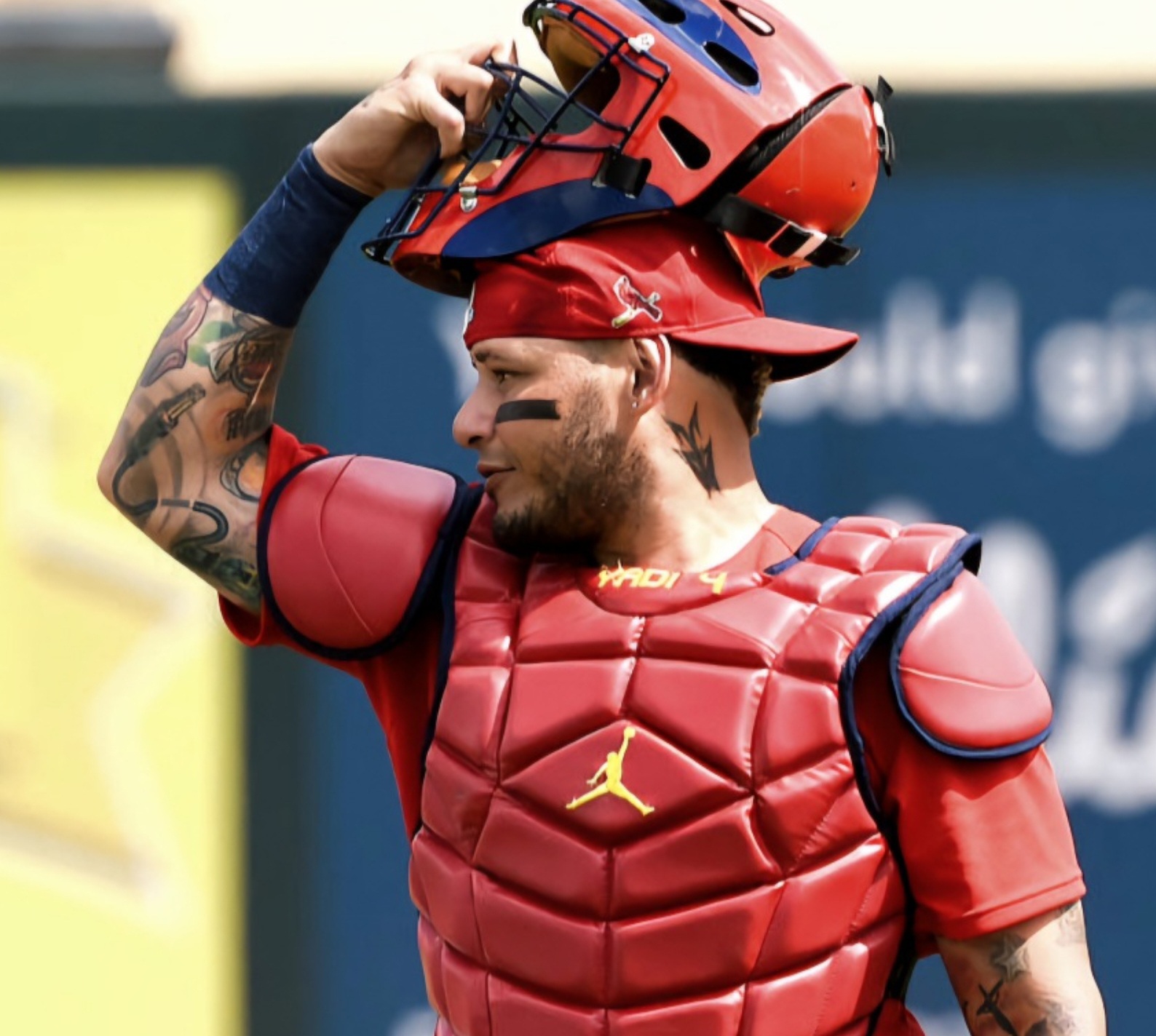 야디어 몰리나 선수가 포수 마스크에 손을 대고 있다.