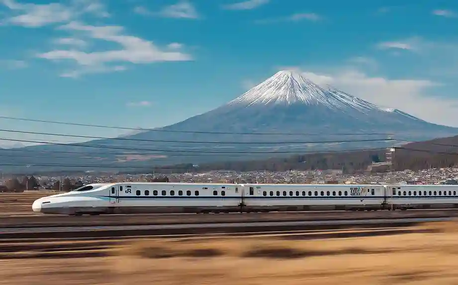 설산 후지산 배경의 고속으로 달리는 흰색 신칸센 열차의 모습