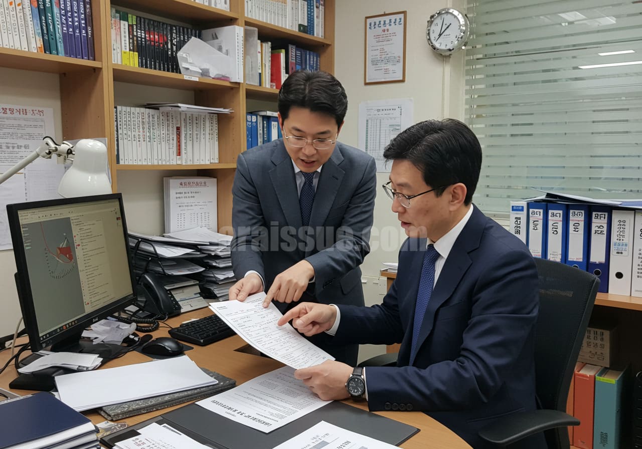 한국 세무사가 자영업자에게 임대소득이 포함된 건강보험료 산정 구조를 설명하는 장면. 책상 위에는 소득 내역서와 계산 자료가 펼쳐져 있으며, 사무실 배경은 서류와 컴퓨터, 책장으로 가득 찬 현실적인 상담 환경.