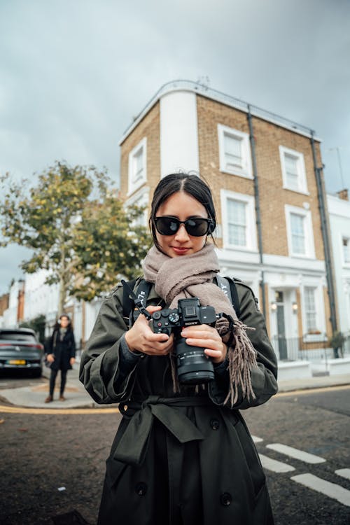 사진을 찍기위해 카메라를 쥐고있는 썬그라스끼고있는 여자사진