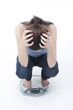 체중계에-올라가서-몸무게를-확인하는-여자