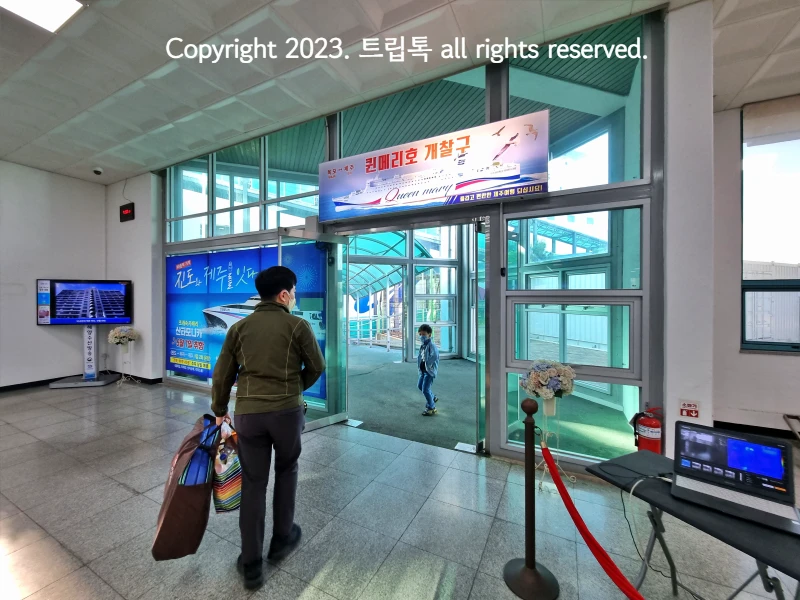 퀸메리호 개찰구하고 적혀있는 간판과 두사람이 배로 가는 모습