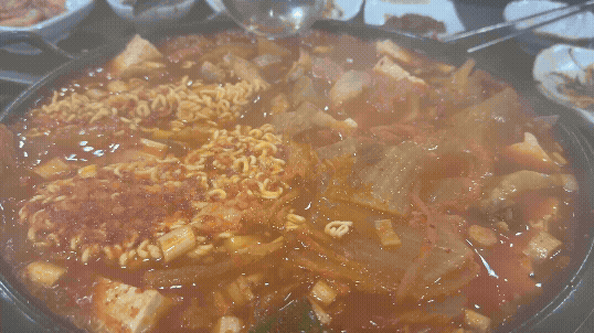두꺼운 김치와 라면 사리가 보글보글 끓고 있는 김치찜 냄비의 모습. 