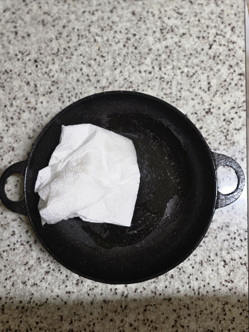 30년 살림 내공이 담긴 무쇠 팬 길들이기(시즈닝) 현장입니다. 기름을 얇게 펴 발라 천연 코팅막을 입히는 이 과정이 주방 도구를 평생 쓰게 만드는 비결입니다