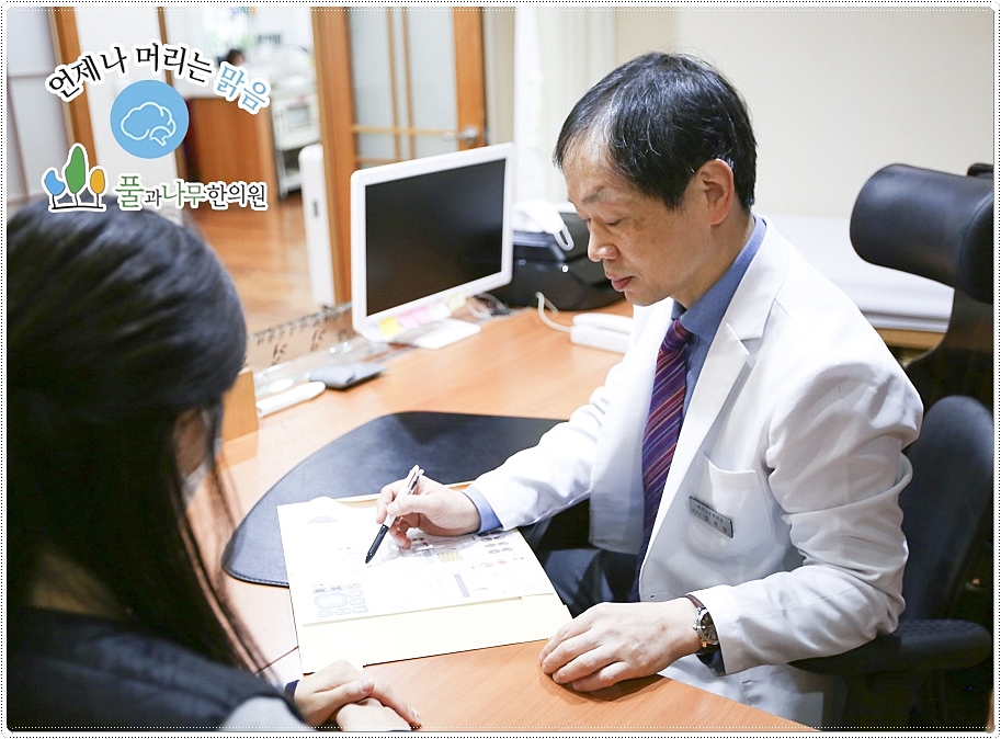 차트를 보며 진료 상담 중인 한의사와 환자의 모습