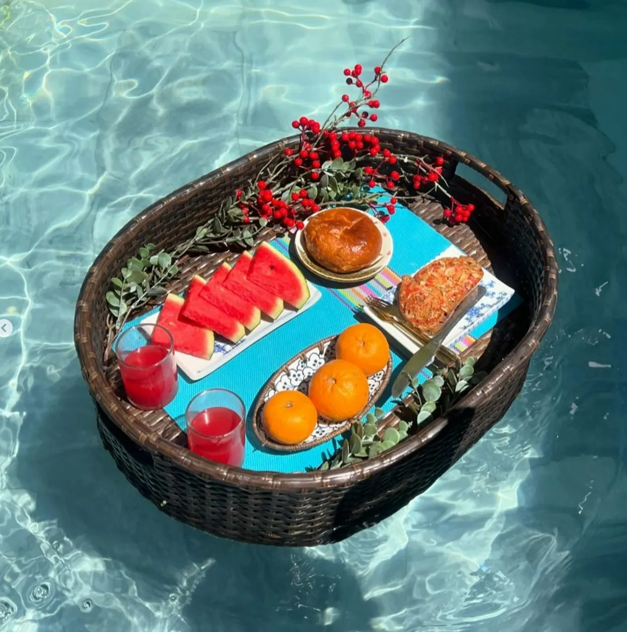 물-위에-라탄-바구니-위에-빵-귤-수박-차-가 담긴-플로팅-시트