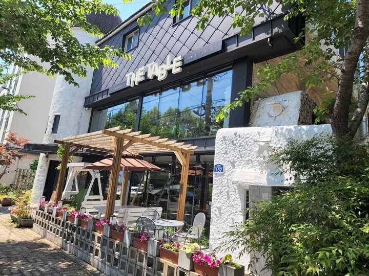 더 테이블건물앞의 흰색그네와 화분들