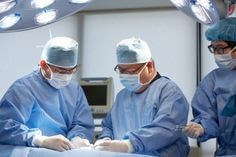 의사-세명이-수술실에서-마스크를-쓰고-집중해서-수술하는-모습