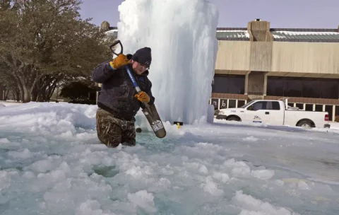 Richardson&#44; Texas&#44; city worker Kaleb Love breaks ice on a frozen fountain on Feb. 16.&amp;nbsp; (LM Otero / Associated Press)