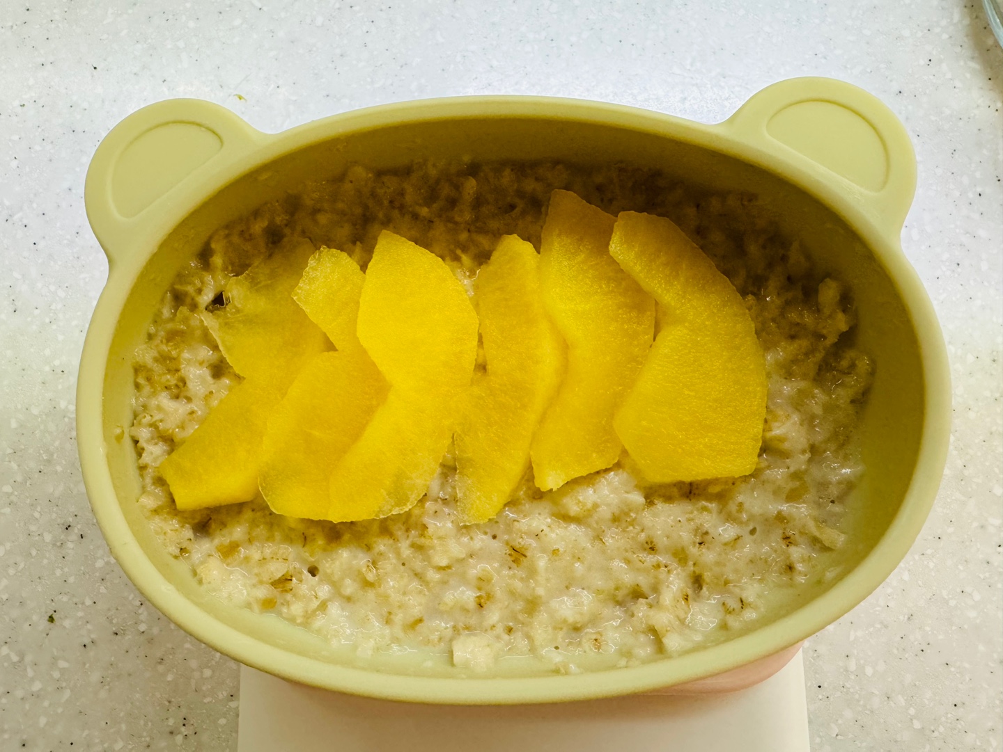 9개월 아기 이유식, 오트밀포리지 위에 찐 사과 슬라이스를 올린 아침 식단