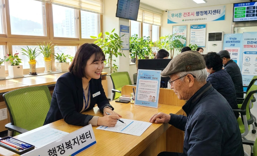 주민센터 창구에서 친절하게 상담받는 어르신