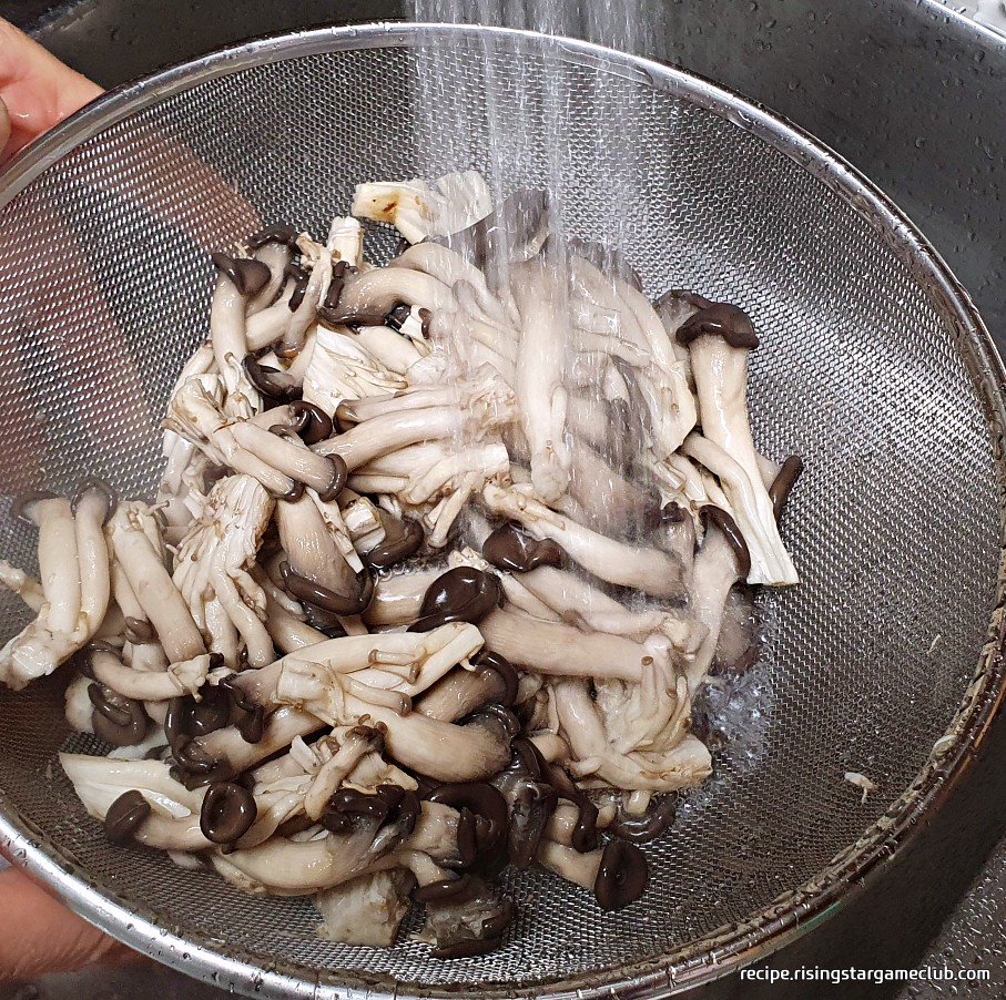 데친 느타리버섯을 흐르는 찬물에 씻는 사진