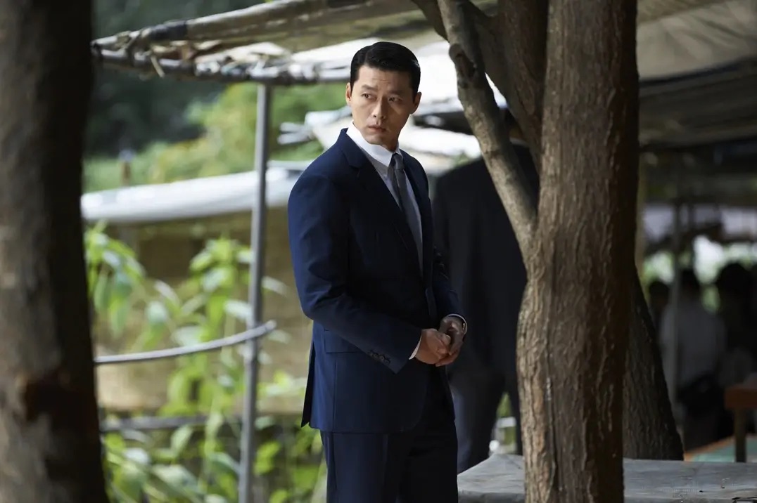 정장 입은 남자가 뒤를 뚫어지게 쳐다보는 모습